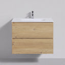 A modern 26-inch wall-mounted bathroom vanity with a light oak wood grain finish, featuring two drawers and a white integrated sink top with a chrome faucet, shown against a neutral gray wall.