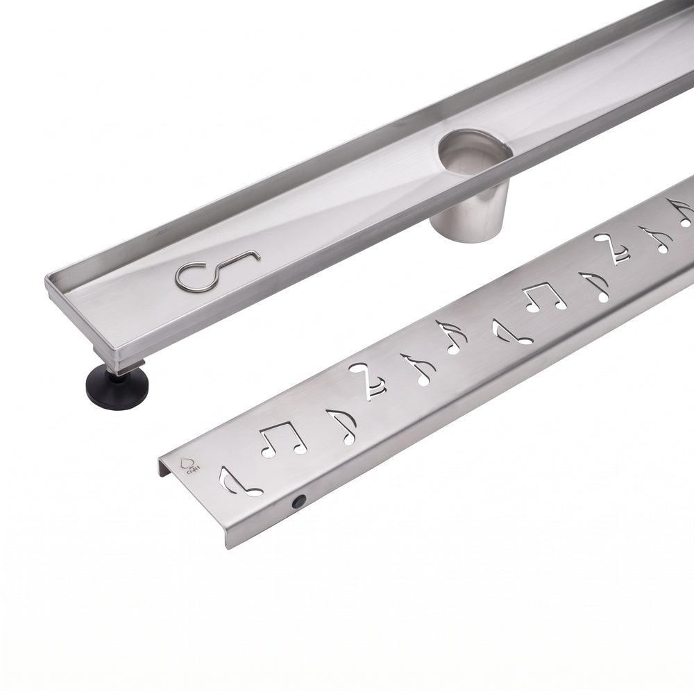 A stainless steel linear shower drain from megabai with a removable musical note grate and adjustable leveling legs.