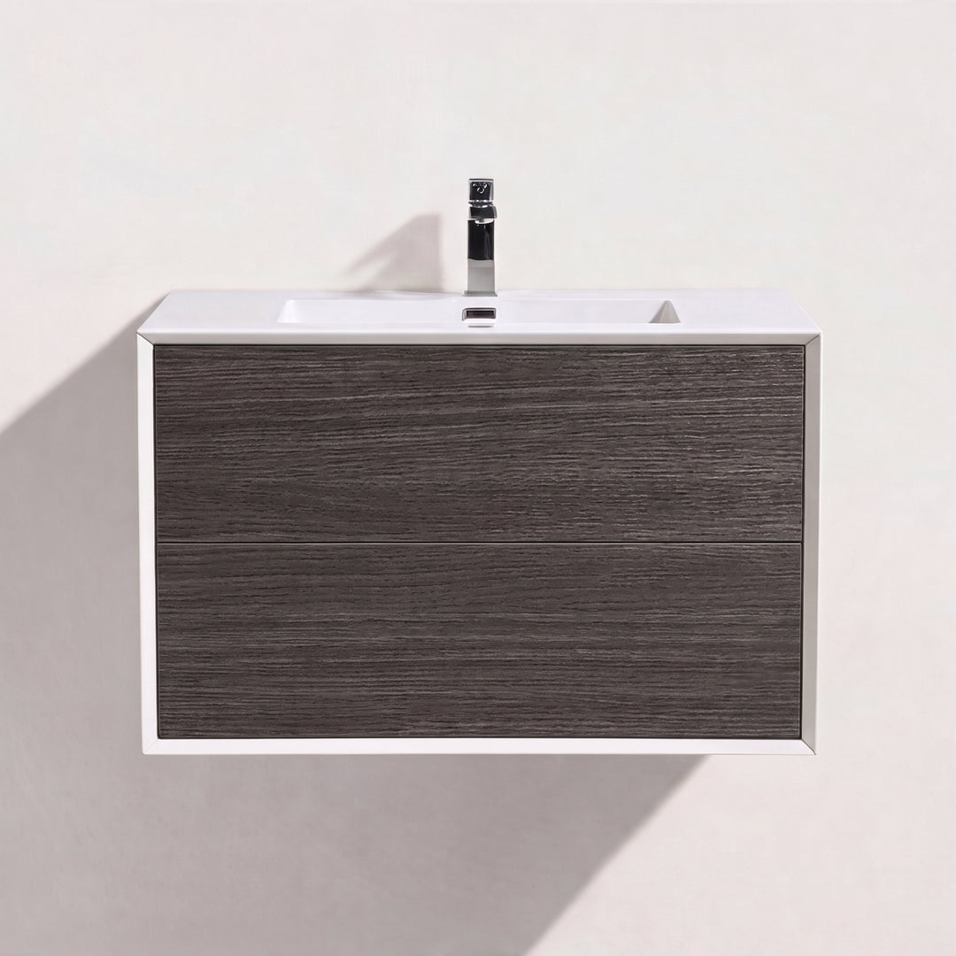 A modern wall-mounted bathroom vanity with two dark brown graphite wood drawers, a white top, and a black faucet, shown against a plain off-white wall.