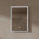 BAI 21030 modern rectangular 24-inch wall-mounted mirror with a slim white LED light with gold frame, shown against a textured beige wall. The mirror has small control touch sensor dots near the bottom center.