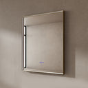 BAI 21031 modern rectangular 30-inch wall-mounted mirror with a slim LED light that's currently off with gold frame, shown against a textured beige wall. The mirror has small control touch sensor dots near the bottom center.
