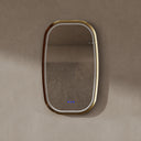 BAI 21041 modern oval wall-mounted vanity bathroom led mirror with a slim gold frame and integrated LED lighting, shown against a textured beige wall with the lights off.