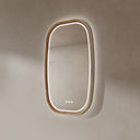 BAI 21043 modern oval wall-mounted led bathroom mirror with a light wood oak frame and integrated LED lighting, shown on a textured beige wall with white lighting side view.