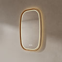 BAI 21043 modern oval wall-mounted led bathroom mirror with a light wood oak frame and integrated LED lighting, shown on a textured beige wall with warm lighting side view.