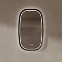 BAI 21044 modern oval LED-backlit vanity bathroom mirror with a dark wood walnut frame, mounted on a textured beige wall with white lighting.