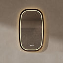 BAI 21044 modern oval LED-backlit vanity bathroom mirror with a dark wood walnut frame, mounted on a textured beige wall with warm lighting.