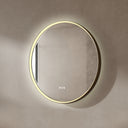 BAI 21051 modern minimalist round 32-inch bathroom vanity mirror with a glowing warm LED light ring and a gold frame, mounted on a textured beige plaster wall.