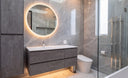 modern bathroom featuring a stone gray floating bathroom vanity from megabai with a round led mirror, smart toilet and large gray neutral porcelain slabs.